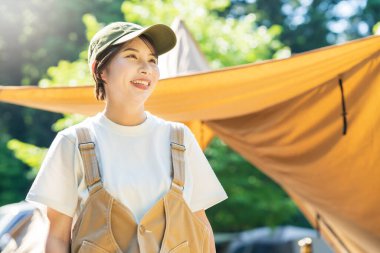 Solo kamp görüntüsü. Çadırda dinlenen genç bir kadın.