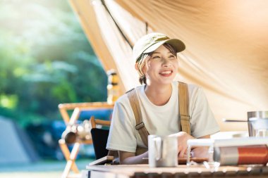 Solo kamp görüntüsü. Çadırda dinlenen genç bir kadın.