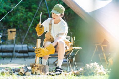 Solo kamp görüntüsü - odun kesen genç bir kadın