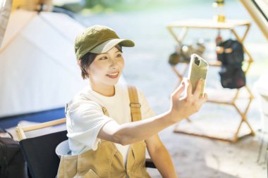 Solo kamp görüntüsü - Kadın akıllı telefonuyla selfie çekiyor 