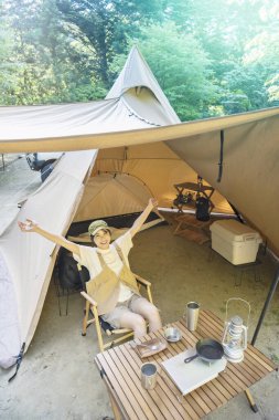 Güzel bir günde tek başına kampta eğlenen bir kadın.