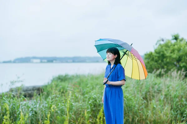 雨の中でカラフルな傘を持っている女性 — ストック写真