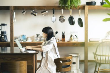 Sıcak bir atmosferde dizüstü bilgisayara bakan bir kadın.