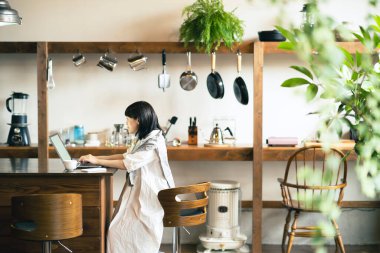 Sıcak bir atmosferde dizüstü bilgisayara bakan bir kadın.