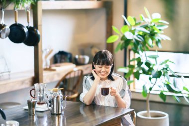 Sakin bir ortamda kahve hazırlayan ve içen genç bir kadın.