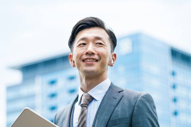 Asyalı işadamı gülümsüyor. 