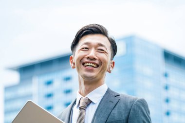 Asyalı işadamı gülümsüyor. 