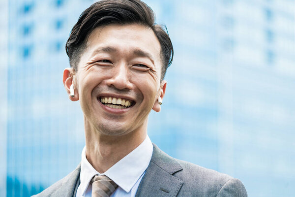 Asian businessman standing in the office district with a smile 