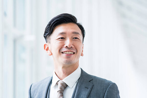 Asian businessman smiling in a bright indoor space