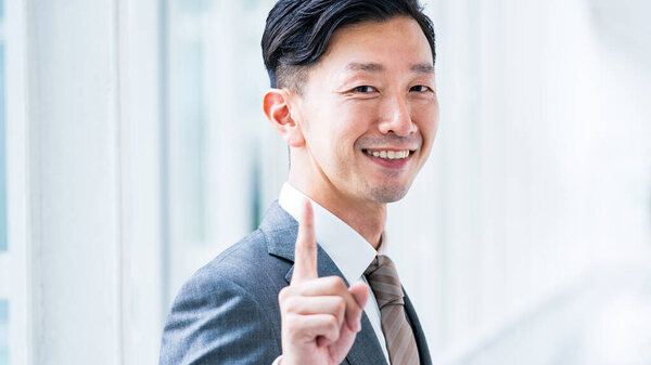 Asian businessman posing with his index finger up