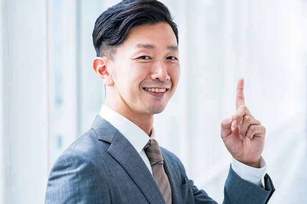 Asiatisk Affärsman Poserar Med Pekfingret Uppåt — Stockfoto