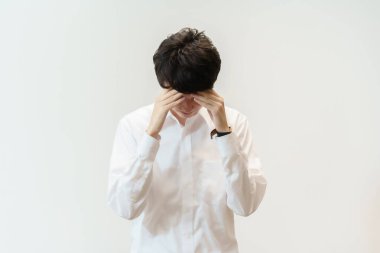 Asyalı adam baş ağrısı çekiyor.