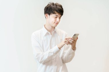 Akıllı telefon kullanan Asyalı genç adam.