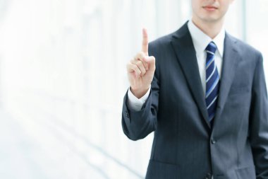 Asyalı işadamı işaret parmağıyla poz veriyor