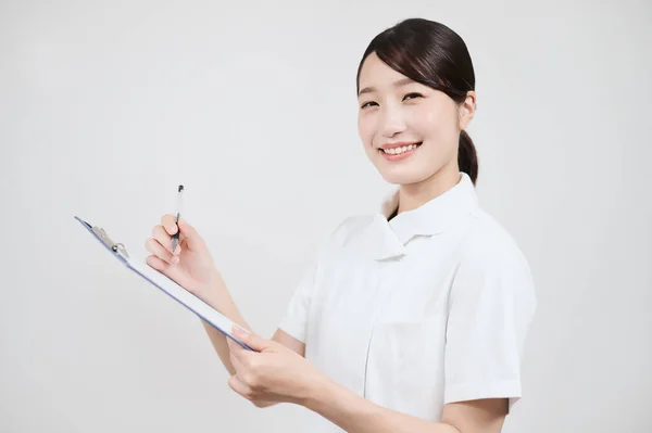 Asiatin Weißen Mantel Füllt Krankenakte Aus — Stockfoto