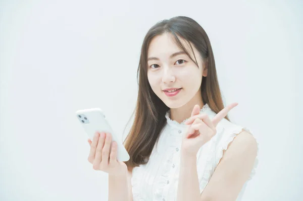スマートフォンを操作するアジアの若い女性 — ストック写真