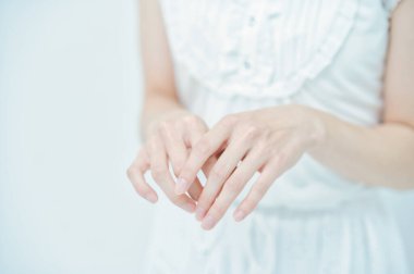 Beyaz elbiseli bir kadının iki eli.