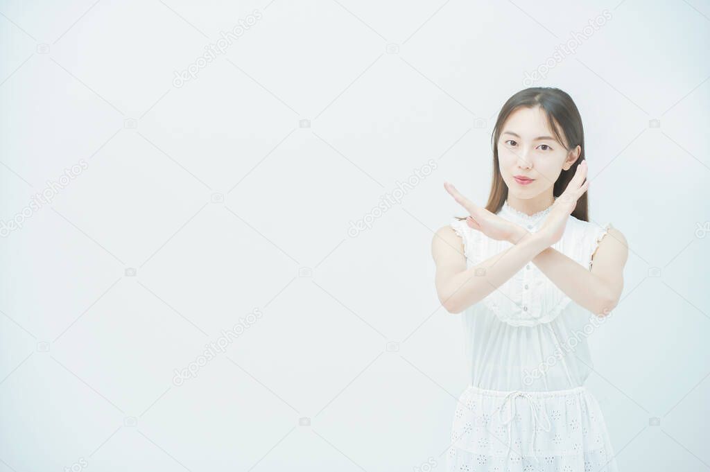 Asian young woman doing a cross hand sign with both hands