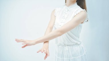 Genç kadın zarif dans ediyor, yüzü olmayan kompozisyon ve beyaz arka plan