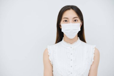 Maske takan ve beyaz bir geçmişi olan genç bir kadın.