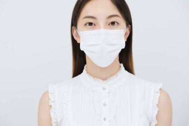 Maske takan ve beyaz bir geçmişi olan genç bir kadın.