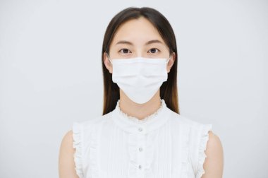 Maske takan ve beyaz bir geçmişi olan genç bir kadın.