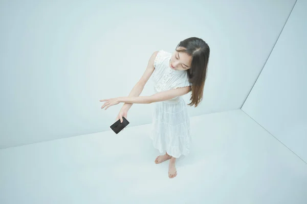 Ασιάτισσα Νεαρή Γυναίκα Χορεύει Κρατώντας Ένα Smartphone — Φωτογραφία Αρχείου