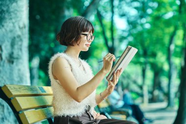 Dışarıda tablet kullanan genç bir kadın.