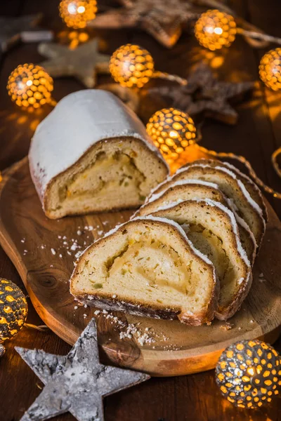 Ahşap bir tahtada Noel arkaplanda ışıklar ve noel süsü, geleneksel Alman noel pastası, dikey stok fotoğraf