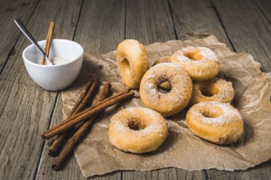 Tahta masadaki kağıtta şekerli ve tarçınlı mini çörekler.