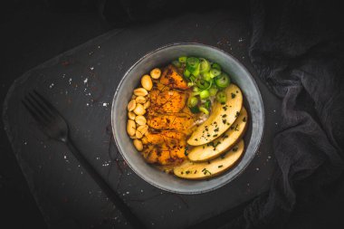 Tavuklu Buda kasesi, pilav, fıstık, arkaplanda elma ve biber sosu, fotokopi alanı ile üstten görüş