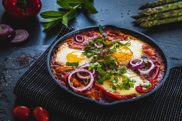 鉄鍋の中のしゃっくり 中東の伝統料理 トマトと目玉焼き ピーマン 野菜やハーブ 卵の上の日当たりの良い側 — ストック写真