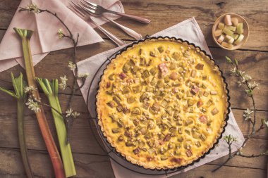 Ev yapımı ravent turtası ve kırsal ahşap arka planda bahar süslemesi.