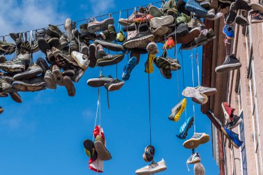 Flensburg, Almanya - 14 Ağustos 2021: Almanya 'nın en kuzeyindeki Flensburg kasabasındaki eski evlerin arasında asılı ayakkabılar