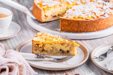 Beyaz ahşap arka planda kavrulmuş bademli ev yapımı bir elmalı turta.