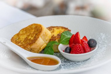 Şerbetli Fransız tostu ve beyaz tabakta böğürtlen, sıcak kahvaltı.