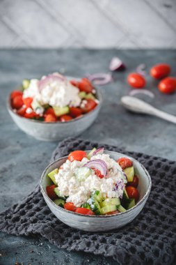 İki kase salatalık salatası ve gri arka planda süzme peynir, düşük karbonhidrat için salata, yüksek protein diyeti. Kopyalama alanı ile dikey.
