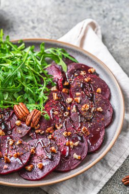 Balzamik jöleli pancar carpaccio ve gri rustik arka planda roket salata, dikey