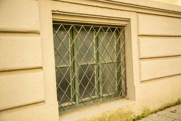 Önünde Parmaklıklar Olan Eski Bodrum Penceresi Yeşil Pencere Bej Cephesi — Stok fotoğraf