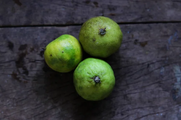 Tam limon, yarım limon, ahşap masada bir dilim limon, seçici odaklanma, konuya odaklanma..