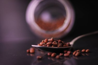 Kurutulmuş fasulye ya da siyah arka planda çelik kaşıkta fasulye.. 