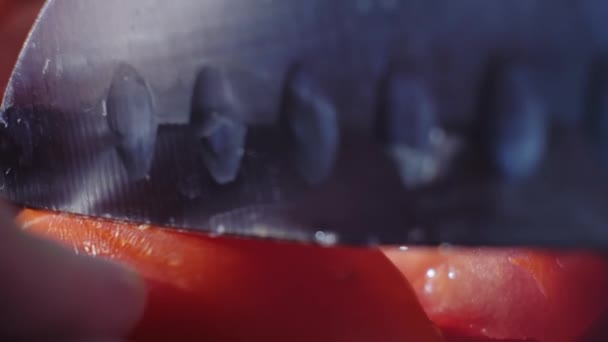 Corte hermoso tomate rojo con cuchillo de cocina, gotas de agua macro video. Tomate fresco húmedo y saludable para comer y cocinar en una granja ecológica — Vídeos de Stock