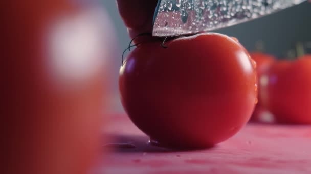 Découpe belle tomate rouge à l'aide d'un couteau de cuisine, gouttes d'eau macro vidéo. Tomate fraîche humide saine pour manger et cuisiner de la ferme biologique — Video