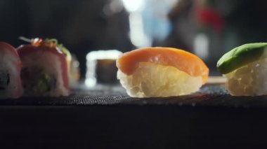 Avokado çiğ somon ile doldurulmuş lezzetli suşi dürümleri, yılan balığı. Balıklı, sebzeli ve pirinçli suşi çeşitleri. Suşi restoranı, yemek teslimatı. Seçici odak