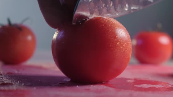 Skär vacker röd tomat med kökskniv, vattendroppar makro video. Färsk våt frisk tomat för att äta och laga mat från ekologisk gård — Stockvideo