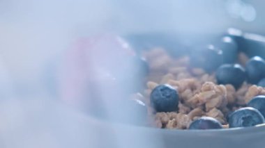 Kaygan böğürtlen ve sağlıklı granola müsli. Sağlıklı kahvaltılık yulaf ezmesi, yaban mersini, çilek ve süt..