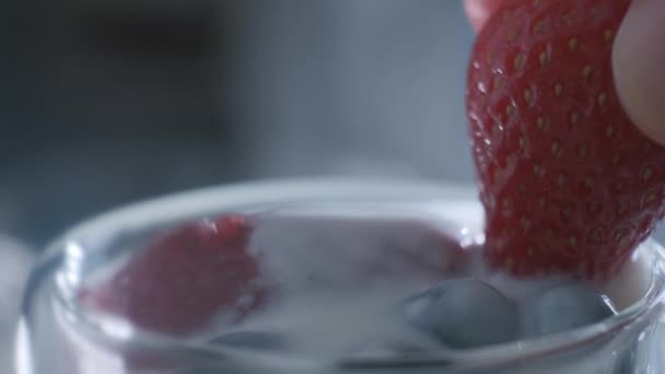 Mananca capsuni cu iaurt. Micul dejun sănătos cu afine, căpșuni și lapte . — Videoclip de stoc