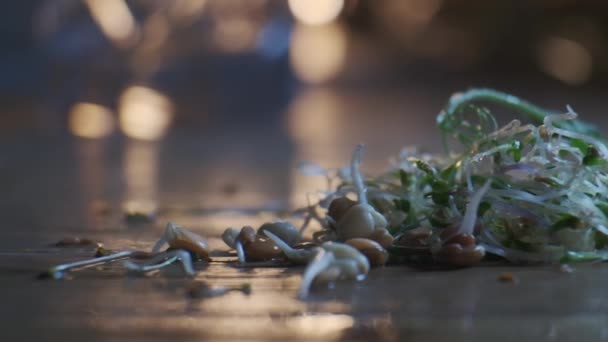 Microgreens y granos germinados en la mesa de madera, vista de cerca en cámara lenta — Vídeos de Stock