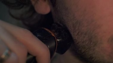 Elektirikli jiletle yanak traşı olan bir adam. Yüzünde sakal kılı var. Hijyen ve bakım. Erkek eli tıraş makinesiyle tıraş olur. 