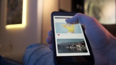 Akıllı telefon kullanan adam sosyal ağda geziniyor, kaydırma yapıyor, kaydırma hareketleri yapıyor. Akıllı telefon kullanıcısı fotoğraflara ve sevdiklerine göz atıyor. Cep telefonu konseptine bağımlılık, yakın çekim.